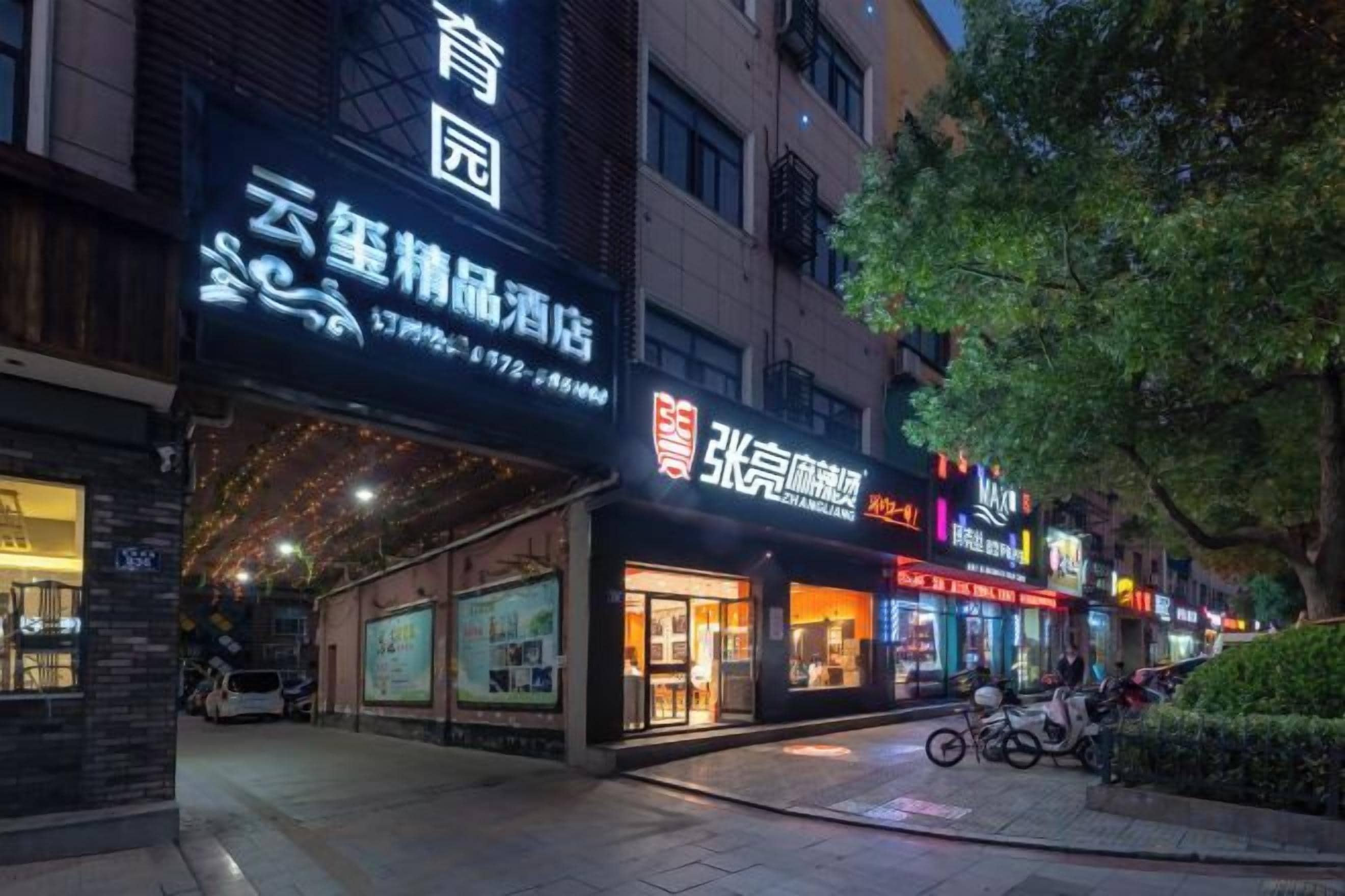 Una calle con comercios, incluyendo un letrero de un hotel.