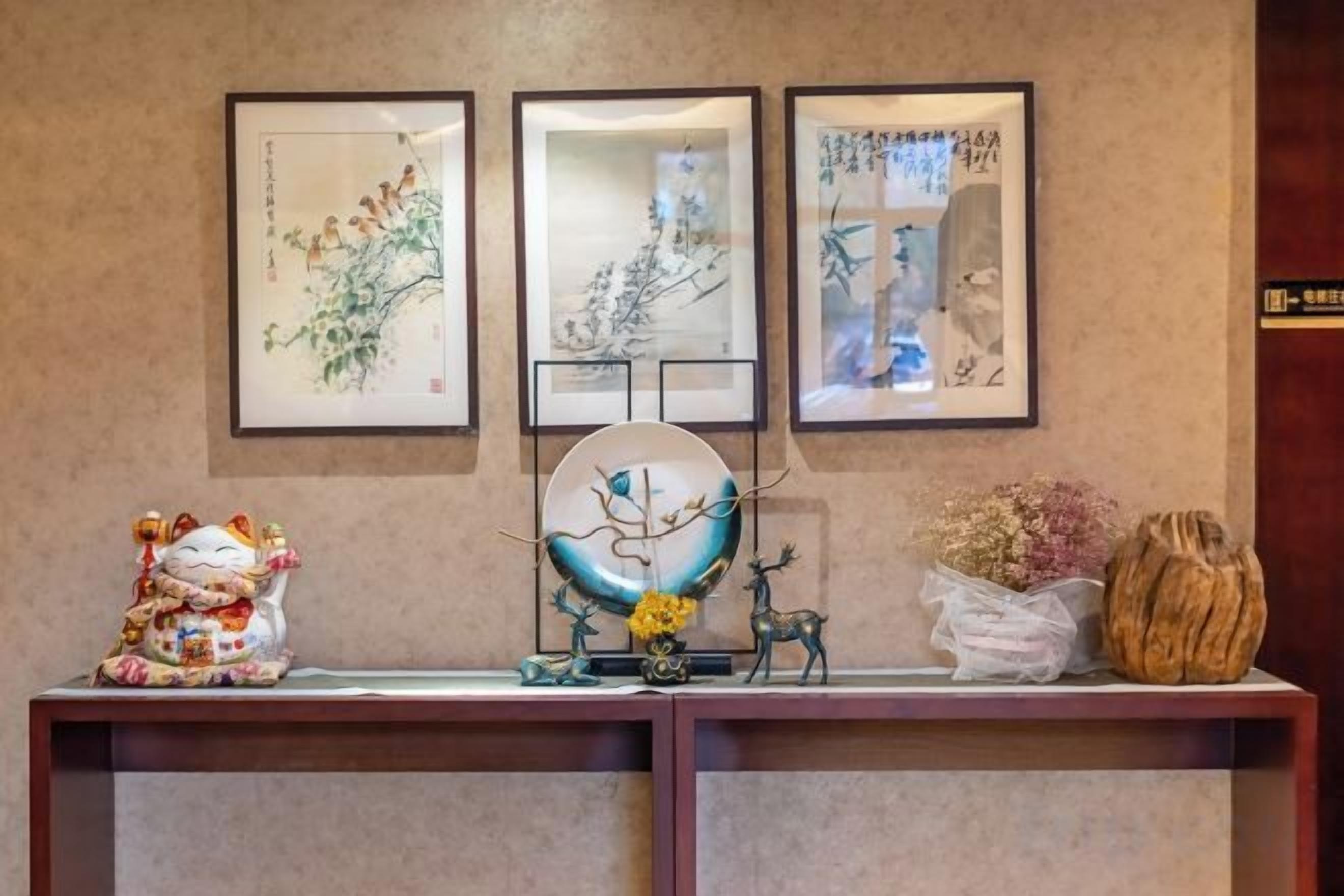 A reception desk with framed artwork, a decorative globe, and a small statue.