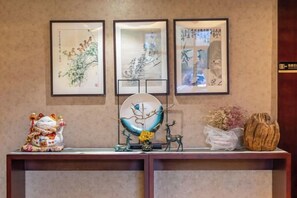 Una recepción con cuadros enmarcados, un globo decorativo y una pequeña estatua.