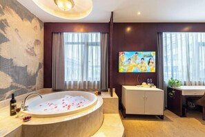 Egy modern fürőszoba, melyben egy különálló, lábas fürdőkád, egy tükörrel ellátott mosdó és egy nagy ablak található, mely természetes fényt biztosít.