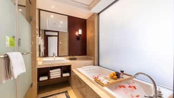 Un baño moderno con una bañera grande, un tocador con espejo y una zona de ducha.