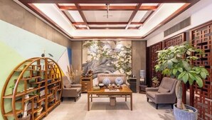 A spacious living area with a central coffee table, a sofa, and a decorative wall with a floral mural.
