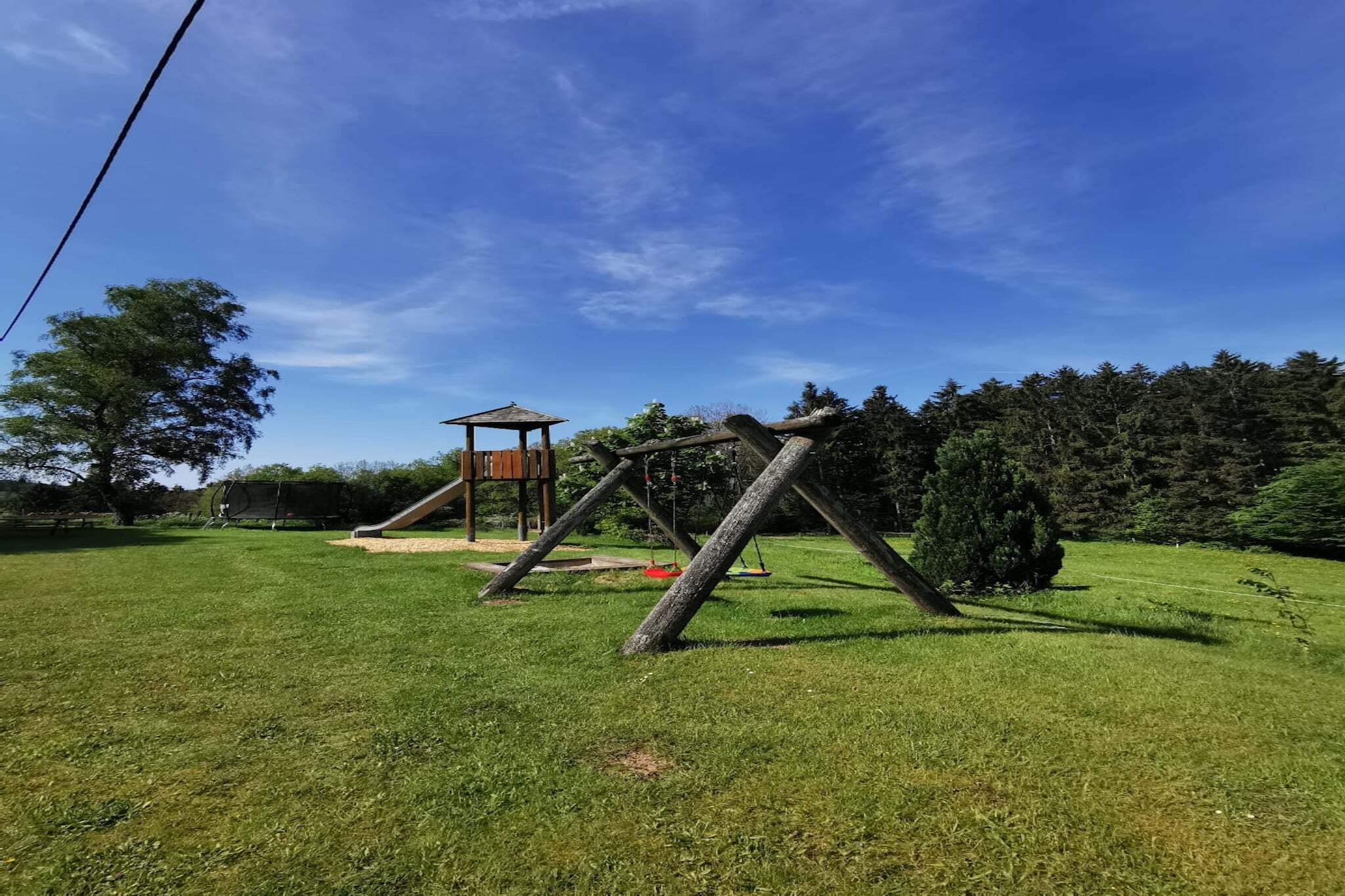 A playground with a swing set and a small pavilion in a grassy area.