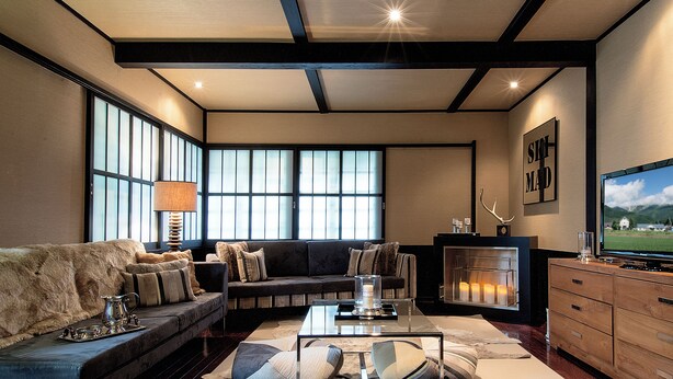 A modern living room with a sofa, a coffee table, and a fireplace. - Hakuba Mountain Lodge (Hakuba)