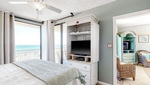 Ein Schlafzimmer mit Bett, Fernseher und Meerblick.