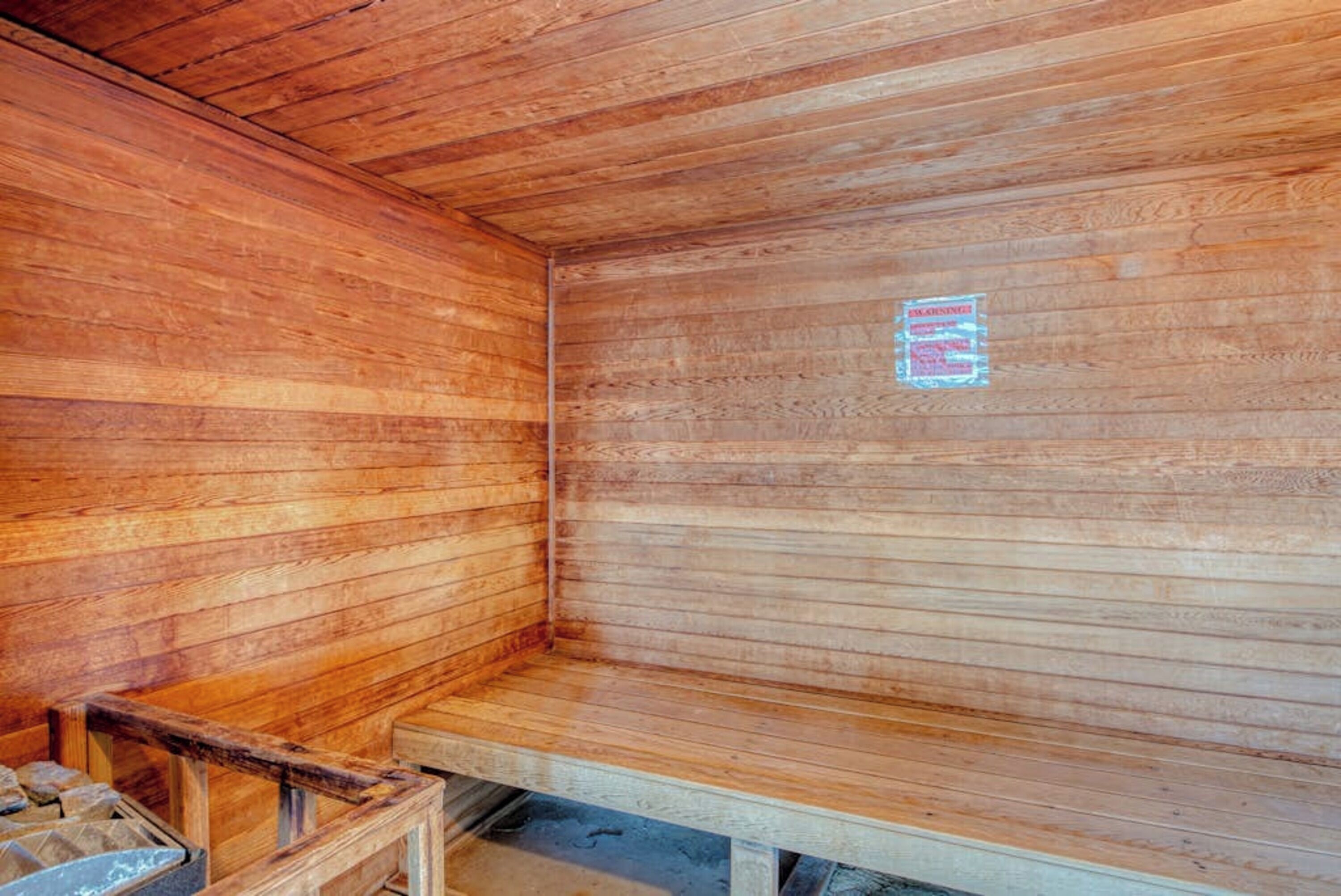 Un sauna avec des murs et des bancs en bois.