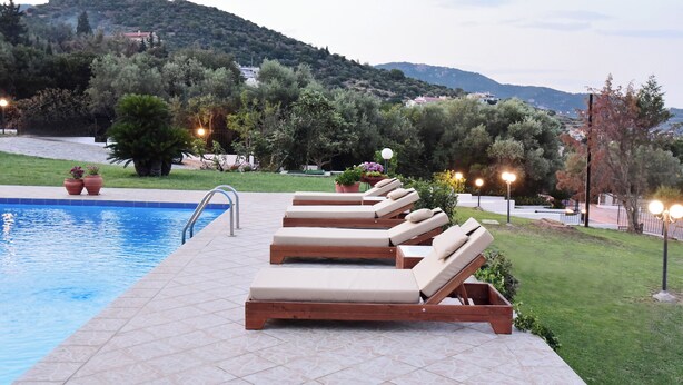 A poolside area with lounge chairs and potted plants.