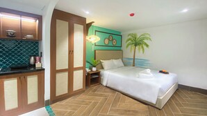 A hotel room with a bed, a nightstand, a lamp, a wall with a palm tree mural, and a kitchen area with cabinets and a tiled backsplash. - Sujet Hotel Da Nang (Da Nang)