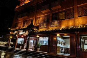 A traditional building with multiple levels, large windows, and a prominent entrance with a decorative gate. - Libo Boutique Guesthouse (Yongshun)