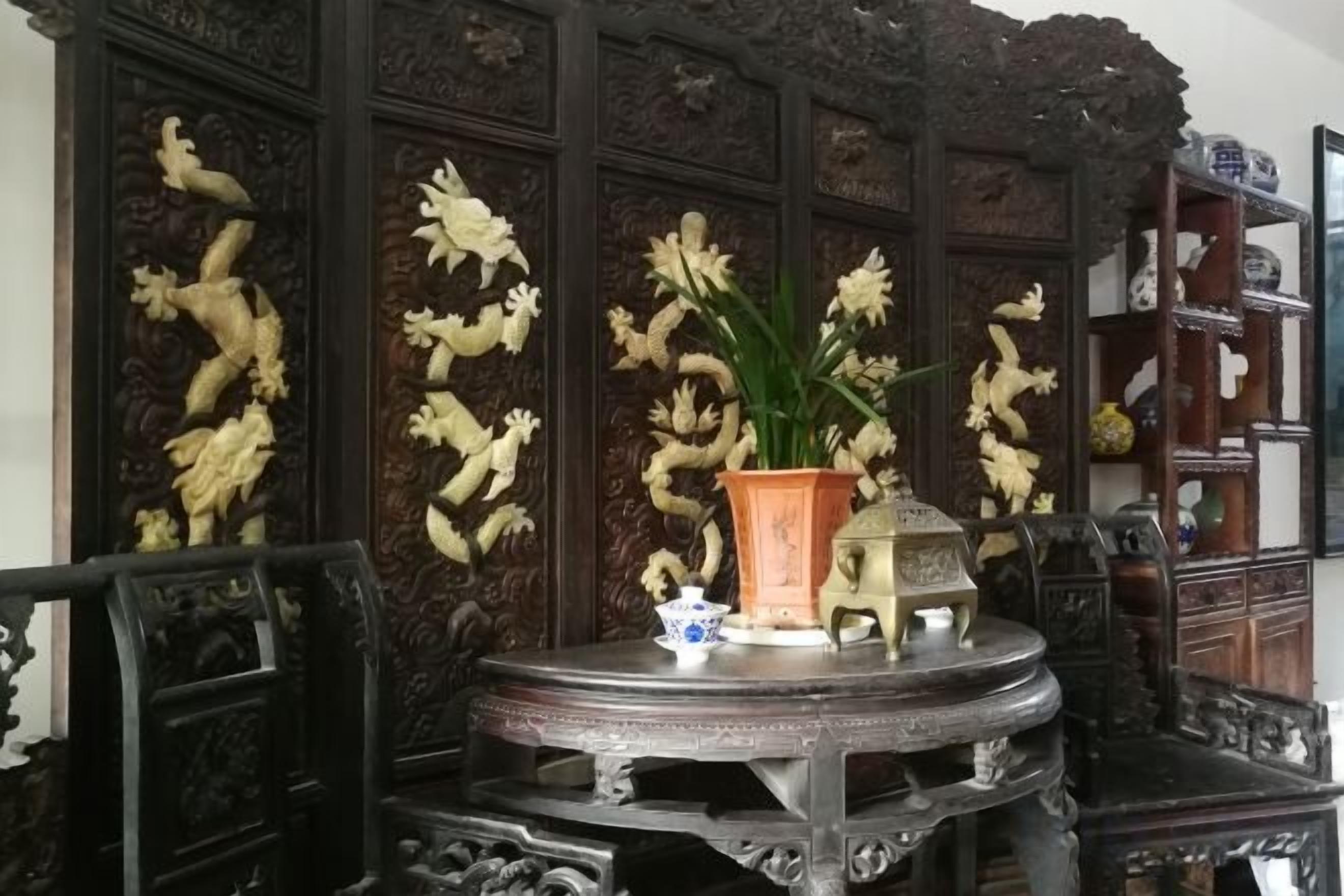 A traditional room with ornate wooden paneling, a round table with a decorative item, and a chair.