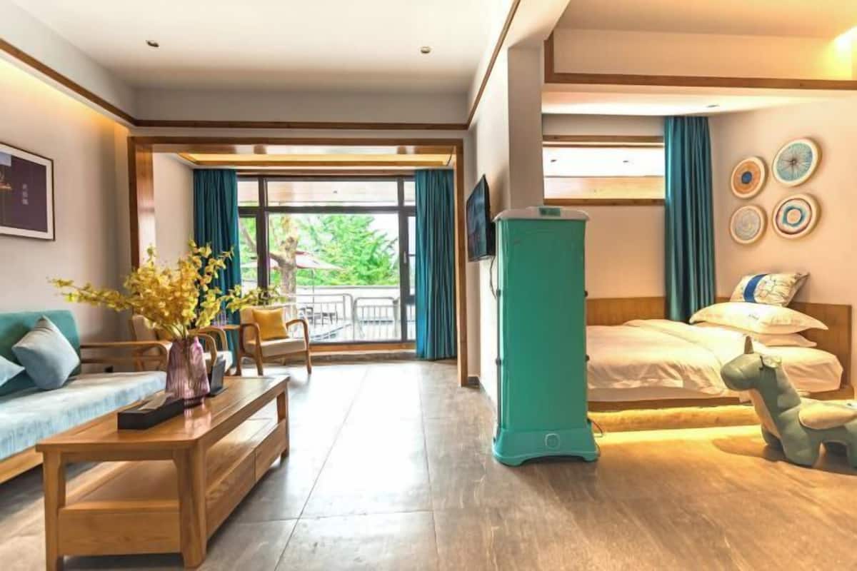 Une chambre d’hôtel avec un lit, un canapé, une table basse et une vue sur l’extérieur.