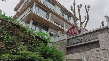 A multi-story building with a stone facade, a red awning, and a staircase leading to the entrance.