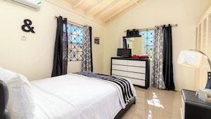 Quarto com cama, penteadeira, espelho e janela com cortinas.