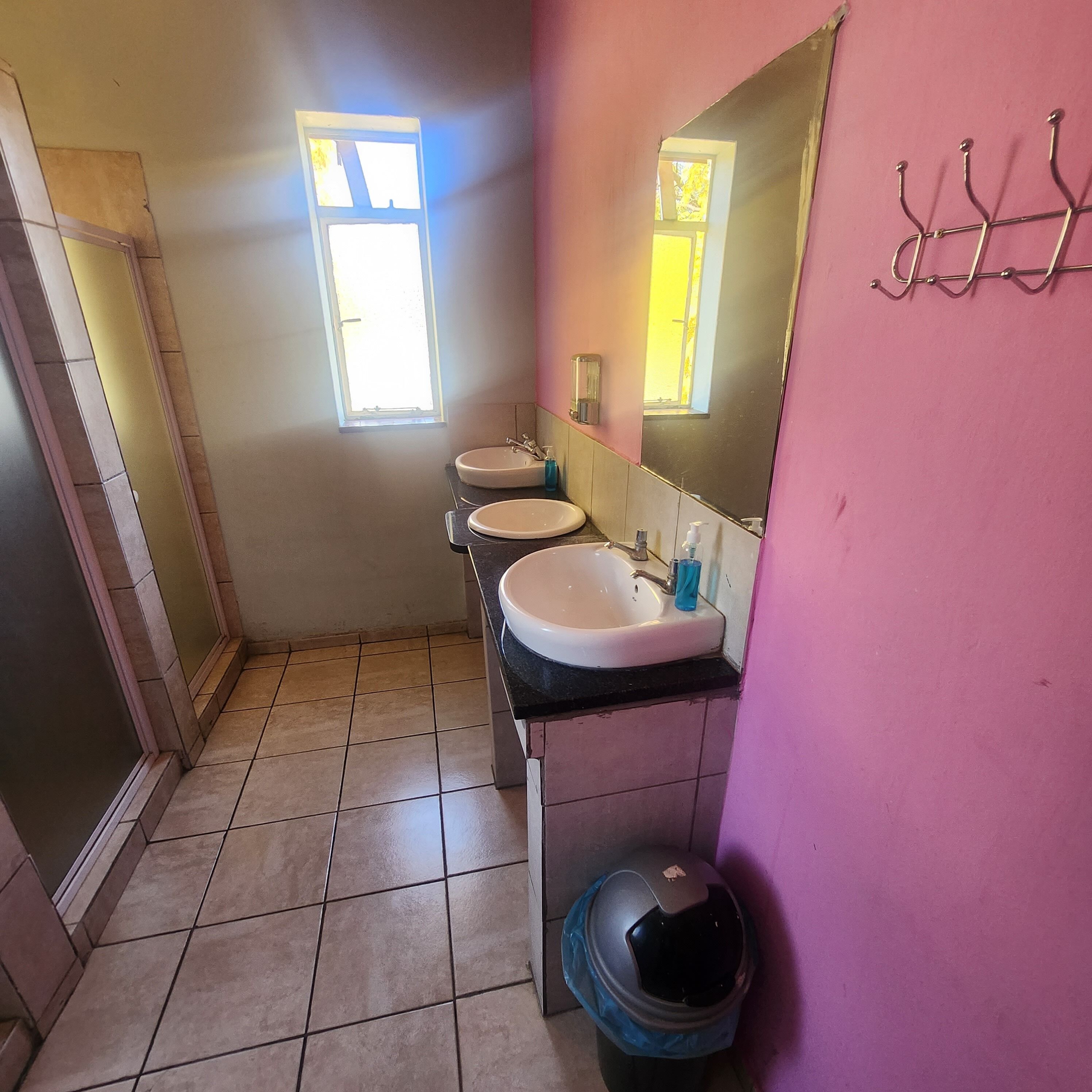 Une salle de bain avec deux lavabos, un miroir et une fenêtre.