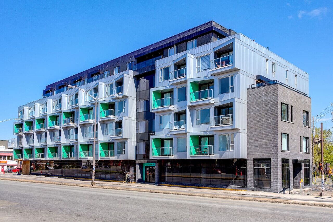 A multi-story hotel with balconies, large windows, and a modern architectural design.