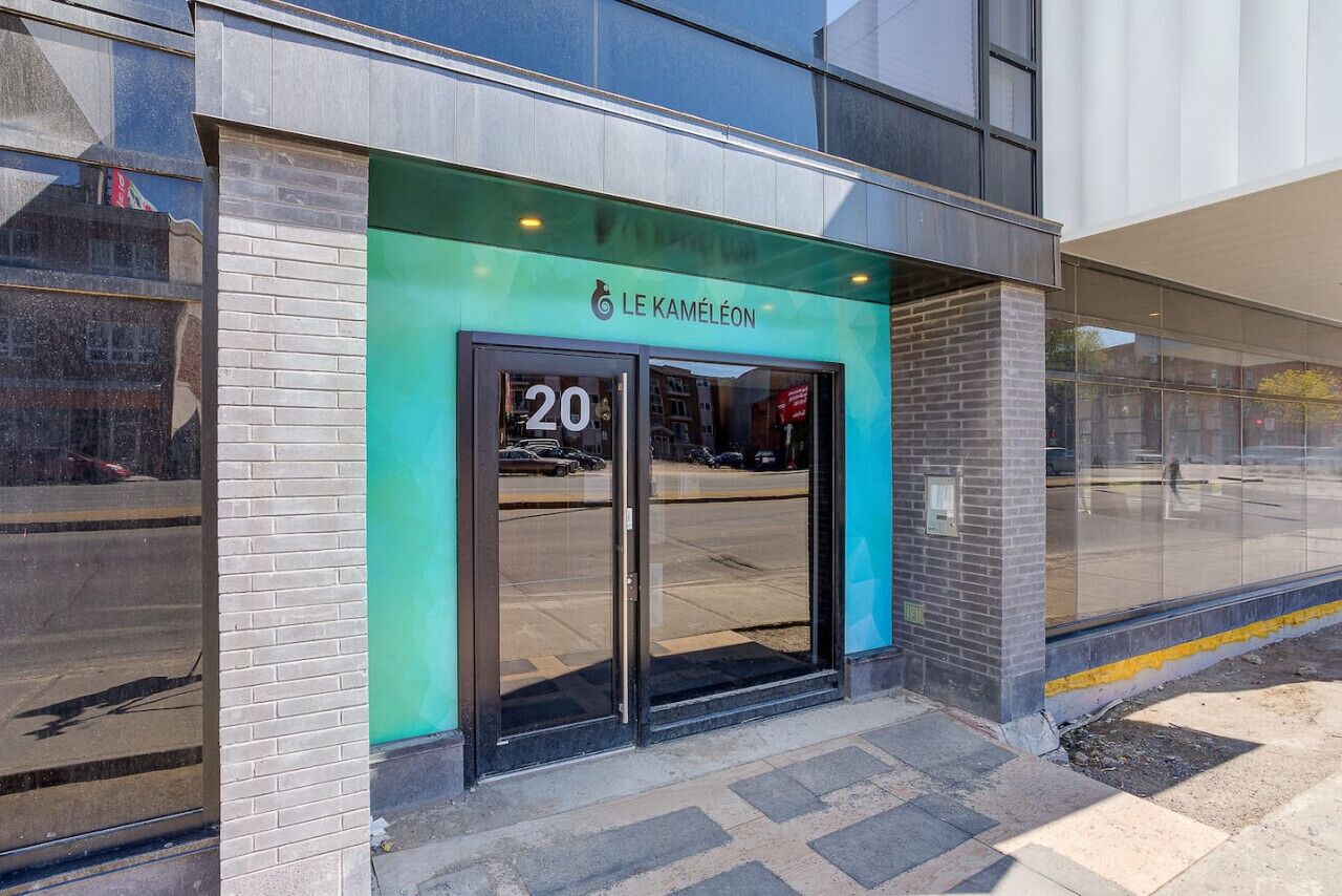 A modern building with a green awning and the number 20 on the entrance.