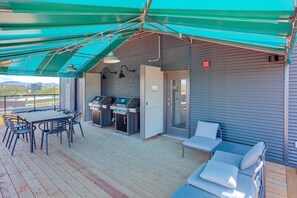 An outdoor deck with a table and chairs, a grill station, and a covered seating area. - Sommet de la basse-ville / Downtown (Ville de Québec)