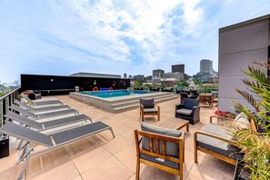 A rooftop pool area with lounge chairs, a pool, and a cityscape view. - El Chico-Rooftop Pool (Québec)