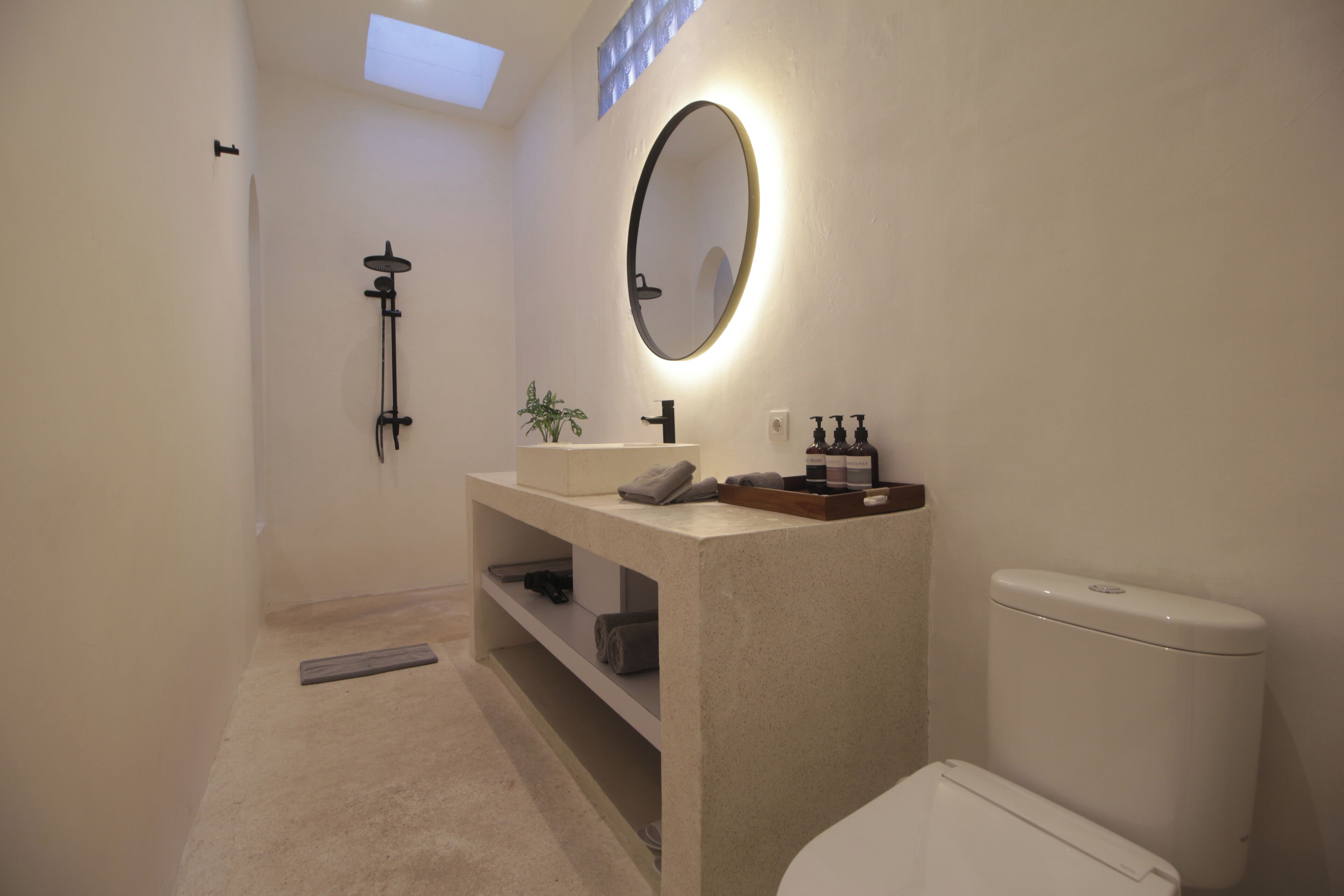 A modern bathroom with a toilet, sink, and shower.