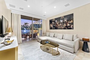 A modern living room with a sofa, coffee table, and artwork on the wall.