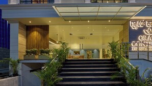 Entrada de hotel con una escalera que lleva a la recepción.
