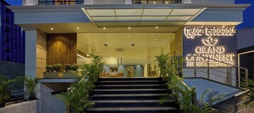 L’entrée d’un hôtel, avec un escalier menant à l’accueil.