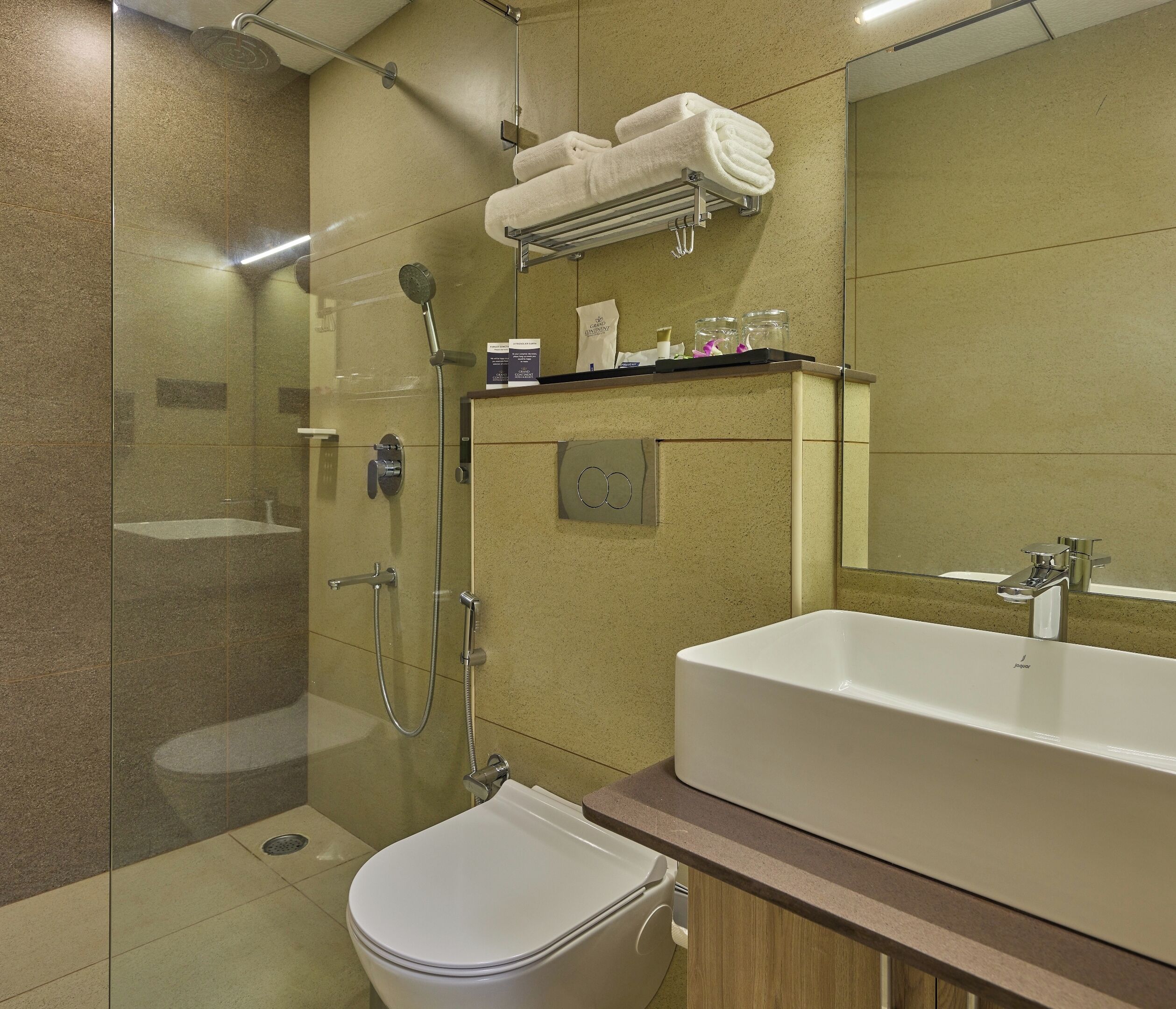 A modern bathroom with a glass-enclosed shower, a white sink, and a large mirror.