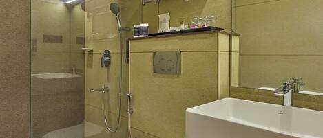 A modern bathroom with a glass-enclosed shower, a white sink, and a large mirror.