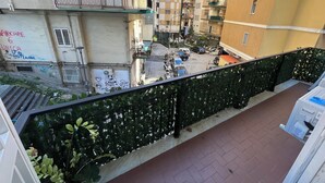 A multi-story residential building with balconies, a gated parking area, and a view of the street below. - F.ROOMS NAPOLI VIA SEMENTINI (Naples)