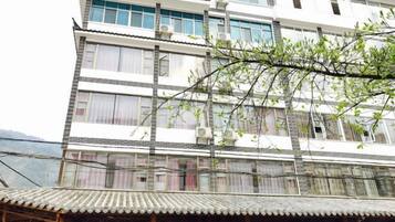 A multi-story building with a traditional architectural style, featuring a tiled roof and multiple windows.