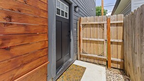 A wooden exterior with a dark door and a wooden gate. - Indy Carriage House in Downtown (Indianapolis)
