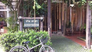A bicycle parked in front of a sign that reads "GUESTHOUSE". - The Sayla Hotel (Chiang Mai)