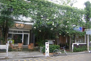 A storefront with a sign for 'SugarTree' and a 'Cosmetics' sign above it. There are chairs and a bicycle outside. - The Sayla Hotel (Chiang Mai)