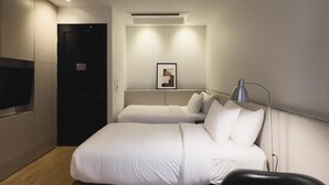 A modern hotel room with a large bed, a desk, a chair, and a flat-screen TV. - The Sayla Hotel (Chiang Mai)
