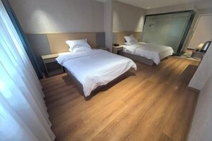 Habitación de hotel con dos camas, piso de madera y diseño moderno.