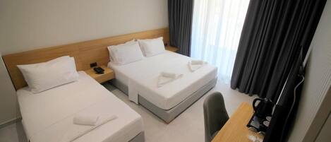 A hotel room with two beds, a desk, and a chair.