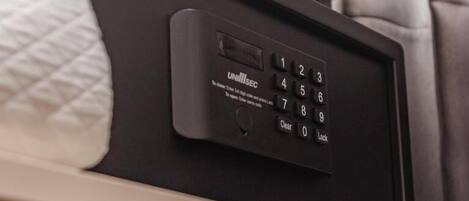 A black electronic device with a keypad and a small screen, likely a control panel for room amenities.