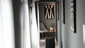 A hallway with a chair, a plant, and a suitcase. - Niklas Boutique Hotel (Sarandë)