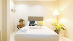 A hotel room with a bed, two bedside tables, a lamp, and a potted plant. - UrbanView @ Lacson Street Bacolod City by RedDoorz (Bacolod)