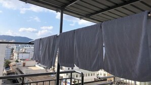 Ein überdachter Balkon mit Blick auf Gebäude und Berge.