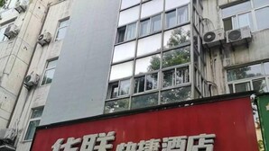 Ein Hotelschild mit chinesischen Schriftzeichen und rotem Hintergrund.