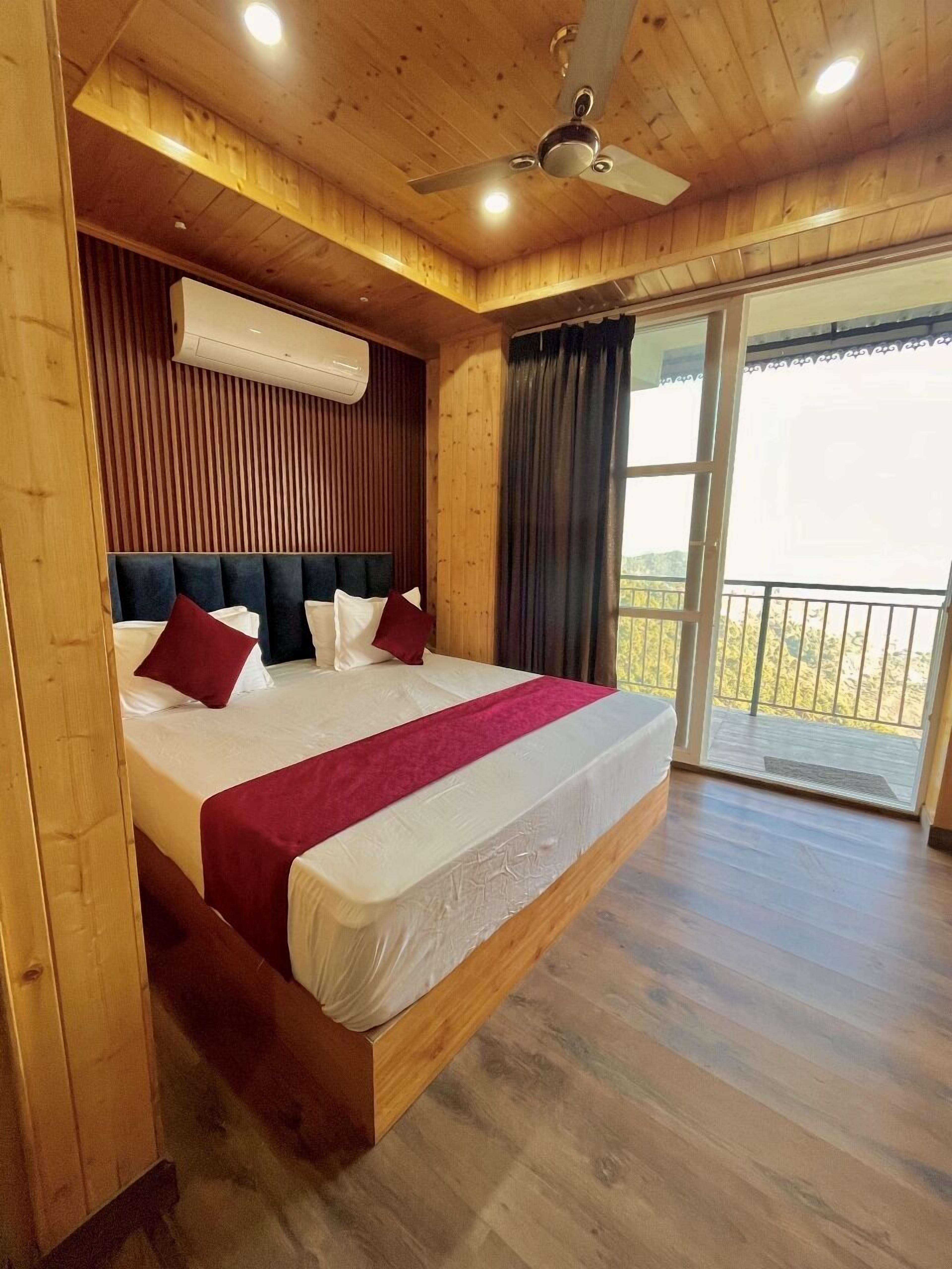 A wooden room with a bed, ceiling fan, and large windows.