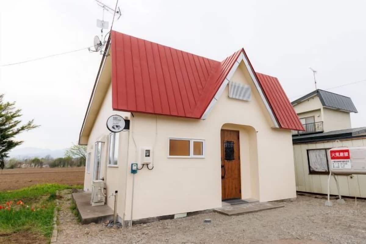 Un petit bâtiment d’un seul étage, avec un toit rouge, une porte en bois et une petite fenêtre.