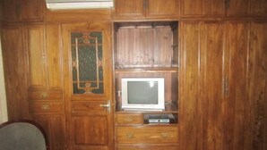 A wooden cabinet with a television and a small electronic device. - Wenfeng Hostel (Huangshan City)