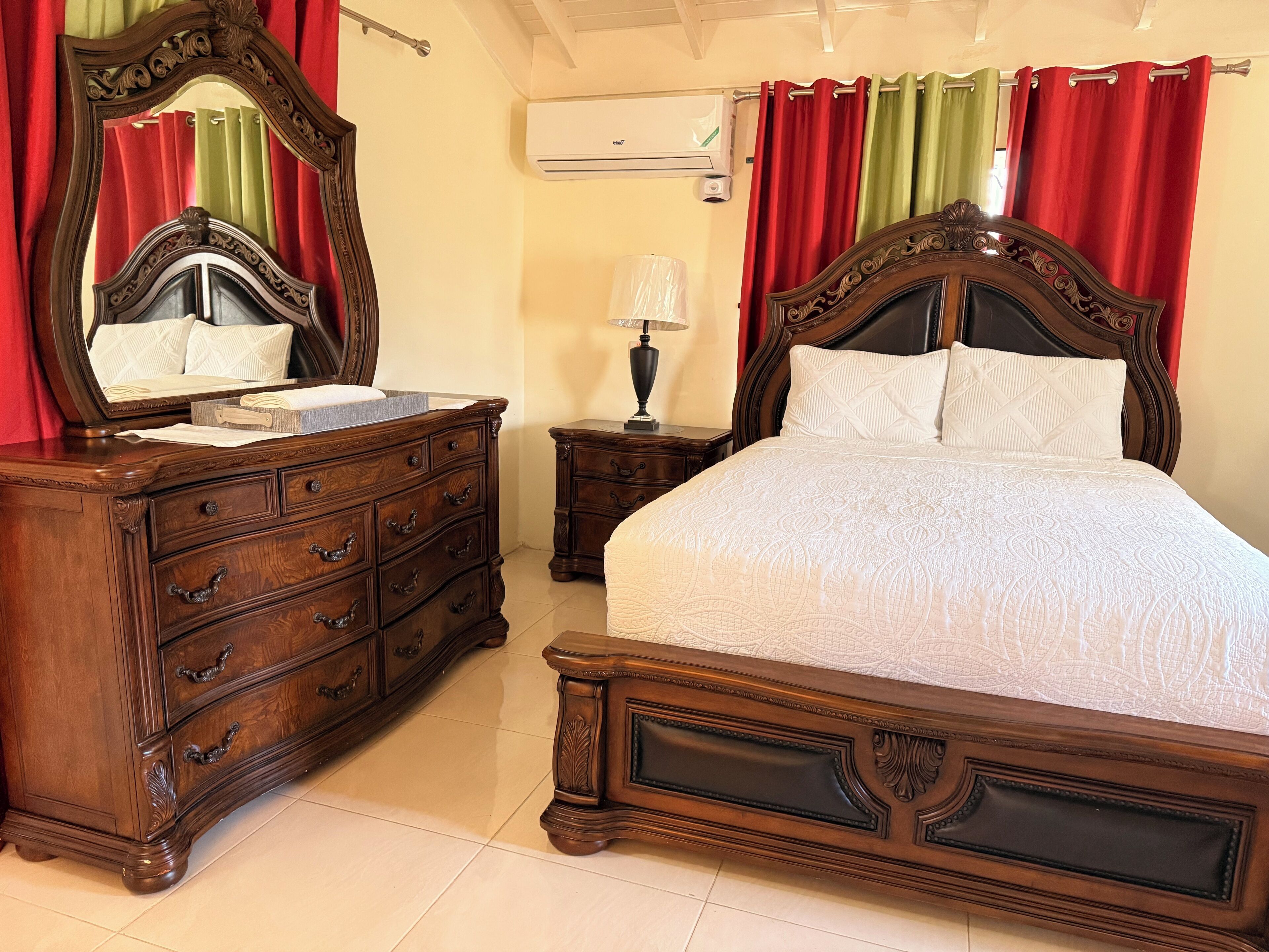 Une chambre à coucher avec un lit en bois, une commode et une table de chevet.