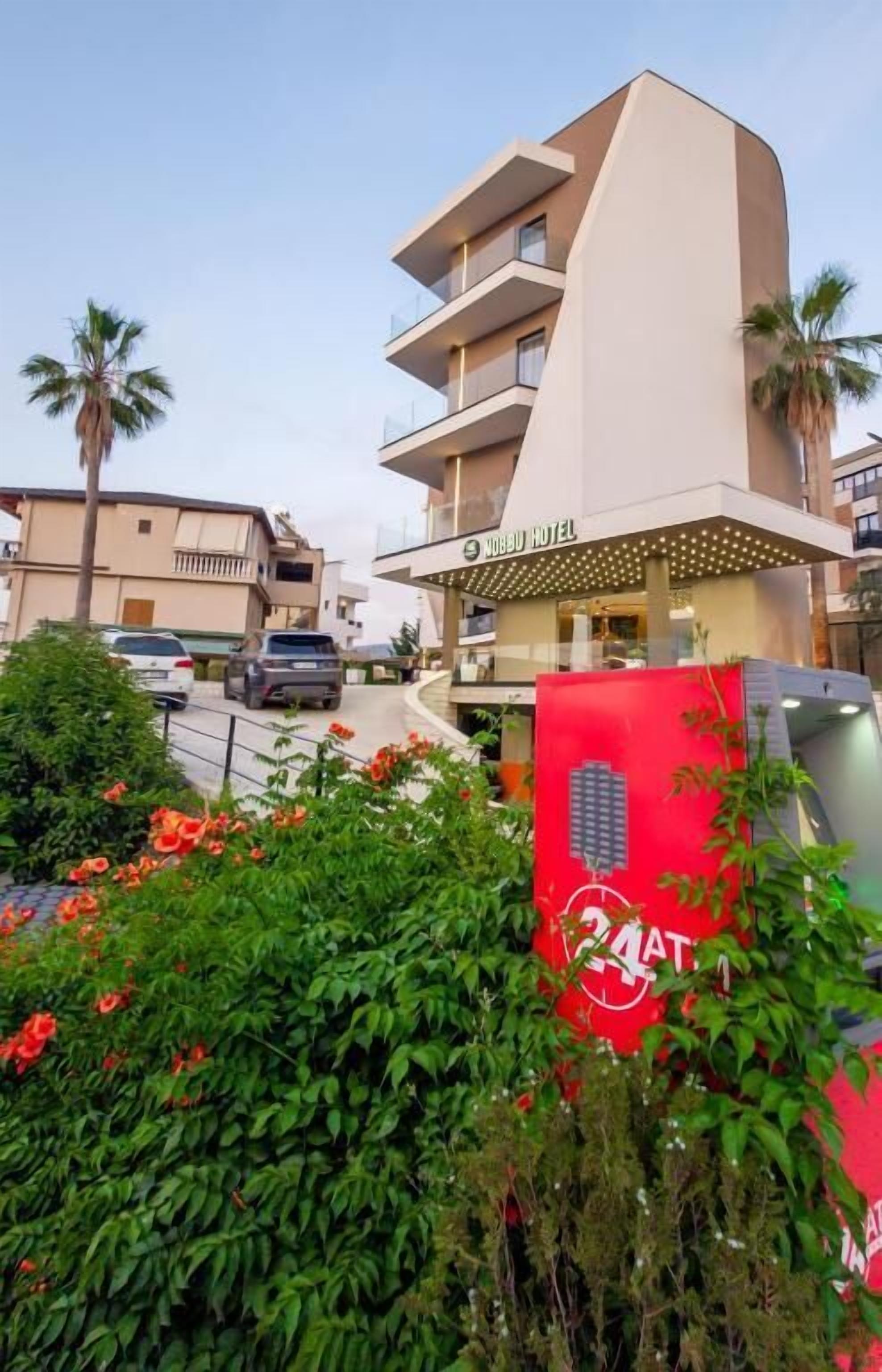A modern hotel with a unique architectural design, featuring multiple balconies and a rooftop terrace.
