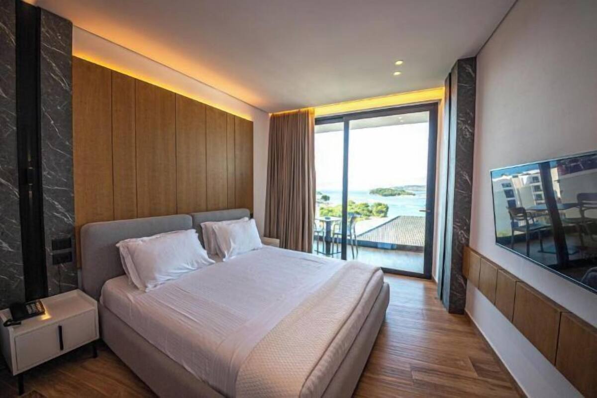 Habitación doble Deluxe, balcón, vista al mar | Minibar, caja de seguridad en la habitación y escritorio