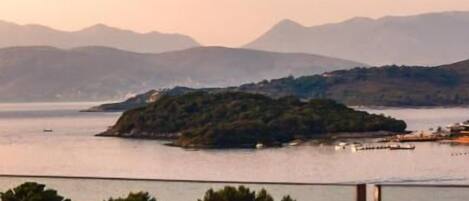A coastal landscape with a view of the sea and distant mountains.