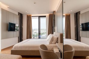 Suite Junior, balkon, pemandangan laut | Minibar, brankas, meja kerja, dan tirai kedap cahaya