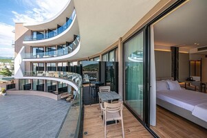 Suite junior, balcón, vistas al mar | Minibar, caja fuerte, escritorio y cortinas opacas